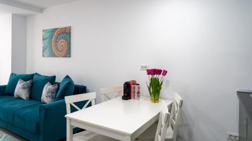 a living room with a blue couch and a white table at Sea View Apartments Olimp - Avenue Hotels in Olimp