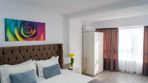 a bedroom with a bed and a painting on the wall at Sea View Apartments Olimp - Avenue Hotels in Olimp
