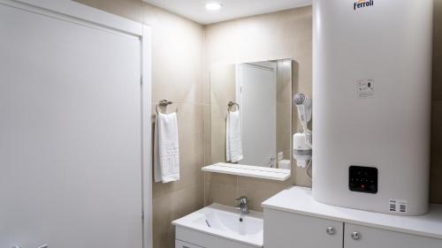 a white bathroom with a sink and a mirror at Sea View Apartments Olimp - Avenue Hotels in Olimp