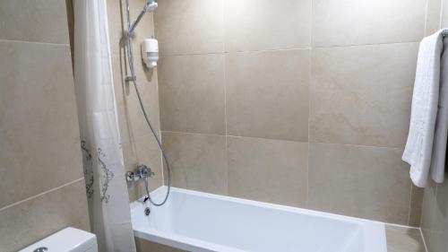 a bathroom with a shower with a tub and a toilet at Sea View Apartments Olimp - Avenue Hotels in Olimp