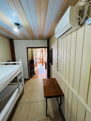 a room with a bed and a table in it at Pousada Rosa Center in Praia do Rosa