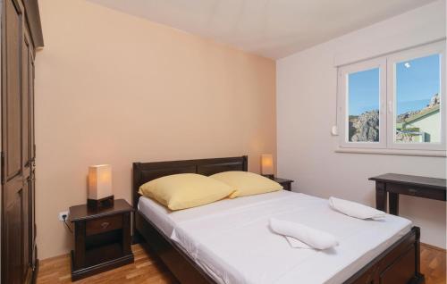 um quarto com uma cama com lençóis brancos e uma janela em Nice Apartment In Omis With House Sea View em Omiš