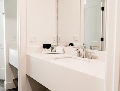 a white bathroom with two sinks and a mirror at The Suites at Fishermen's Village - 2 Bedroom Suites in Punta Gorda