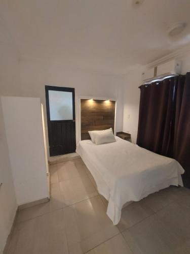 a bedroom with a white bed and a window at EL ANCLA in Ciudad del Carmen