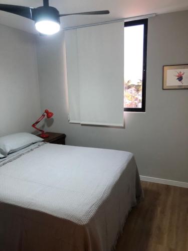 ein Schlafzimmer mit einem weißen Bett und einem Fenster in der Unterkunft Apartamento na Prata in Campina Grande