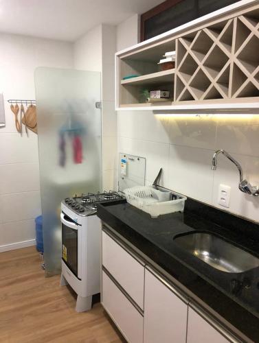 a kitchen with a sink and a stove at Apartamento na Prata in Campina Grande