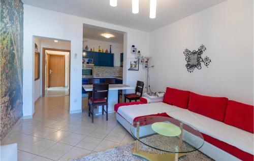 a living room with a red couch and a kitchen at Two-Bedroom Apartment In Klek in Klek