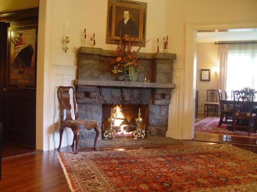 a living room with a fireplace and a chair at 1900 Inn on Montford in Asheville