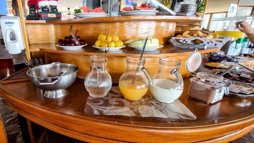 Complejo Turístico CapArcona في فيلا جيزيل: طاولة عليها ثلاث مزهريات زجاجية مملوءة بعصير البرتقال