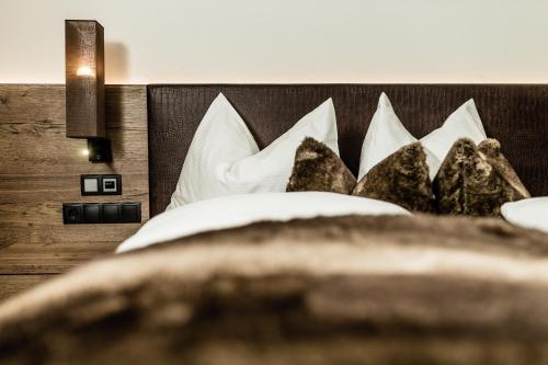 a bedroom with a bed with white pillows at Apartments Villa Gardena - Gardenahotels in Selva di Val Gardena