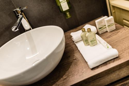 a bathroom with a sink and towels on a counter at Apartments Villa Gardena - Gardenahotels in Selva di Val Gardena