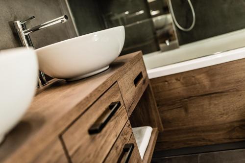 a bathroom with a bowl sink on a wooden vanity at Apartments Villa Gardena - Gardenahotels in Selva di Val Gardena
