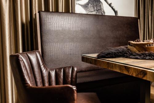 a brown leather chair sitting next to a table at Apartments Villa Gardena - Gardenahotels in Selva di Val Gardena