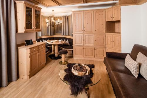 a living room with a couch and a table at Apartments Villa Gardena - Gardenahotels in Selva di Val Gardena