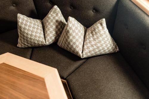 a couch with two pillows on top of it at Apartments Villa Gardena - Gardenahotels in Selva di Val Gardena