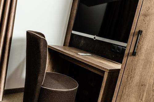 a room with a desk with a tv and a chair at Apartments Villa Gardena - Gardenahotels in Selva di Val Gardena