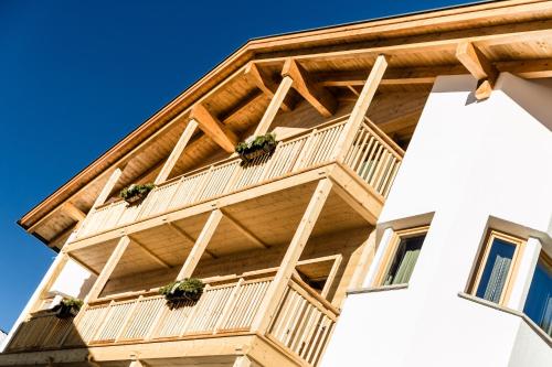 a building with a balcony with plants on it at Apartments Villa Gardena - Gardenahotels in Selva di Val Gardena