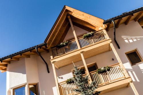 a building with a balcony with plants on it at Apartments Villa Gardena - Gardenahotels in Selva di Val Gardena