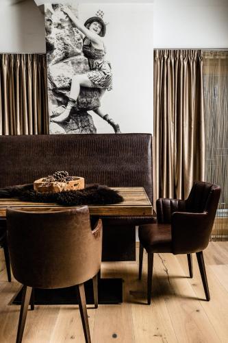 a dining room with a table and two chairs at Apartments Villa Gardena - Gardenahotels in Selva di Val Gardena