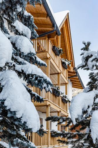 a log cabin in the snow at Apartments Villa Gardena - Gardenahotels in Selva di Val Gardena