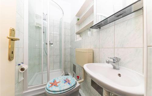 La salle de bains est pourvue de toilettes, d'un lavabo et d'une douche. dans l'établissement Gorgeous Apartment In Kastel Stafilic With Wifi, à Kaštela