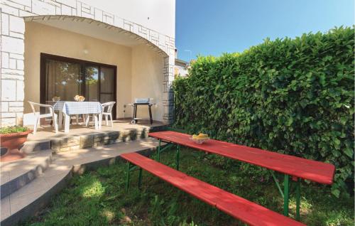 a red bench on a patio with a table at 1 Bedroom Awesome Apartment In Sisan in Šišan