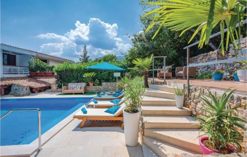 a backyard with a pool with lounge chairs and a house at Stunning Home In Icici With Outdoor Swimming Pool in Ičići