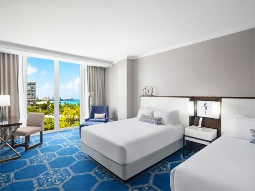a hotel room with two beds and a desk at Fairmont El San Juan Hotel in San Juan