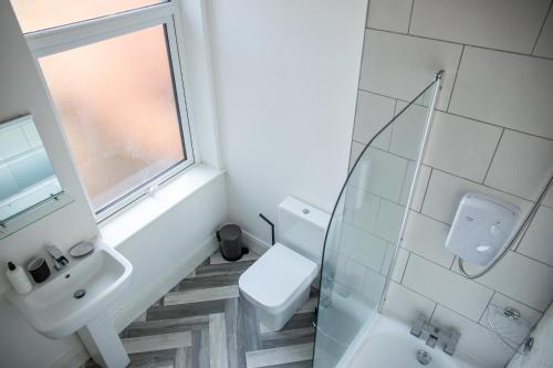 baño con aseo y lavabo y ventana en Withnell Stays - Apartment Two, en Blackpool