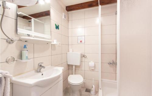 a white bathroom with a toilet and a sink at Gorgeous Home In Kringa With Outdoor Swimming Pool in Kringa
