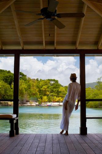 a person standing on a porch looking at the water at GoldenEye in Oracabessa