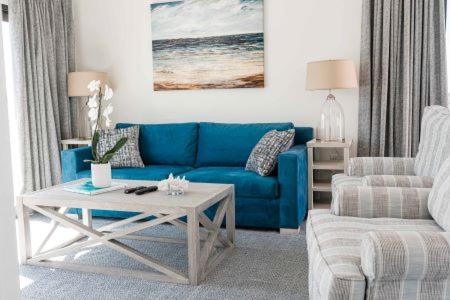 a living room with a blue couch and a coffee table at The Suites at Fishermen's Village - 2 Bedroom Suites in Punta Gorda