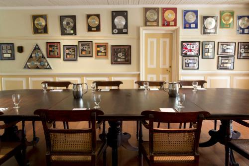 a dining room with a table and chairs and pictures on the wall at Strawberry Hill in Newcastle