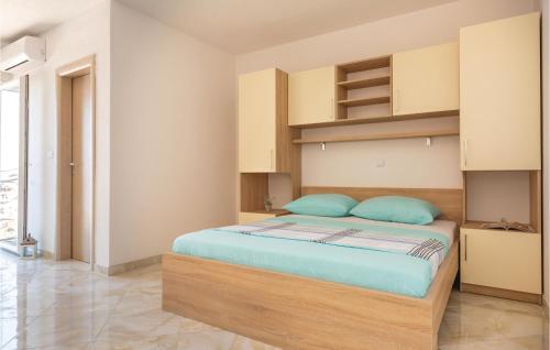 1 dormitorio con 1 cama grande con almohadas azules en Beautiful Apartment In Krvavica With Kitchen, en Krvavica