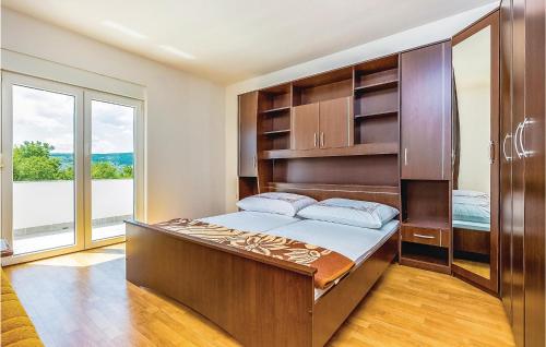a bedroom with a large bed and a large window at 2 Bedroom Awesome Apartment In Grizane in Grižane