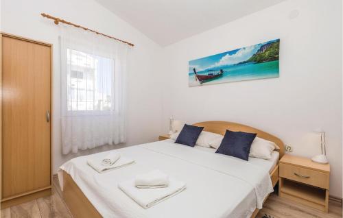 una camera da letto con un grande letto bianco con cuscini blu di Gorgeous Apartment In Povljana With Wifi a Povljana (Pogliana)