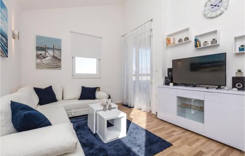 Biały salon z białą kanapą i telewizorem w obiekcie 2 Bedroom Beautiful Apartment In Pag w mieście Pag