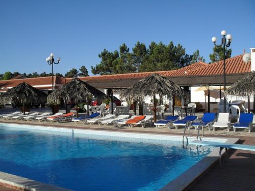 a swimming pool with lounge chairs and a swimming pool at Lobateira Villas in Fernao Ferro