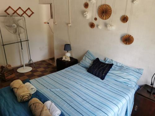 a bedroom with a bed with blue sheets and a fan at Doña Isabel 1 in Gualeguay