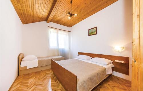 two beds in a room with white walls and wooden ceilings at Stunning Home In Sabunike-privlaka With 4 Bedrooms And Wifi in Nin