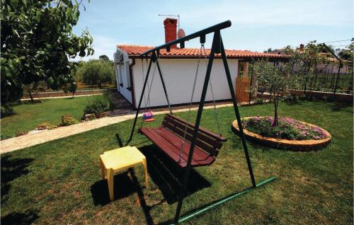a swing in a yard with a house at 2 Bedroom Beautiful Home In Liznjan in Ližnjan