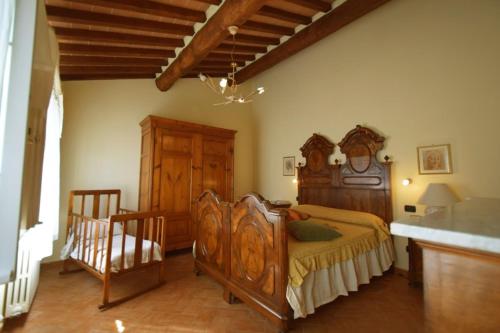 um quarto com uma cama de madeira e um armário de madeira em Ringo, the true Tuscany Country House em Capannori