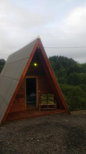 a small cabin with a roof with a porch at CHALÉ ESTÂNCIA OURO VERDE in Lages