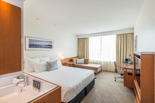 
a hotel room with a large bed and a large window at Novotel Christchurch Cathedral Square in Christchurch
