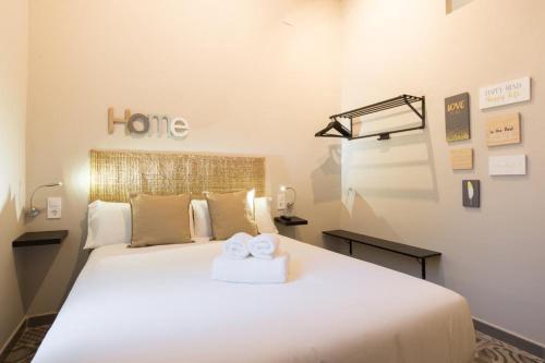 1 dormitorio con 1 cama blanca grande y 2 toallas en HISTORICAL CENTER OLLERIAS en Málaga