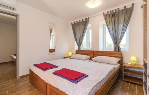 a bedroom with a bed with two towels on it at Awesome Home In Marcana With Kitchen in Orbanići