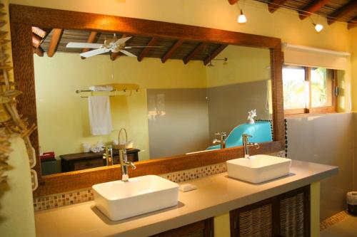 a bathroom with two sinks and a large mirror at Casa Kaukan in Zihuatanejo