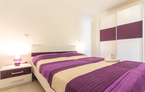 a bedroom with a purple bed with a stuffed animal on it at Awesome Apartment In Premantura With 1 Bedrooms, Wifi And Outdoor Swimming Pool in Premantura