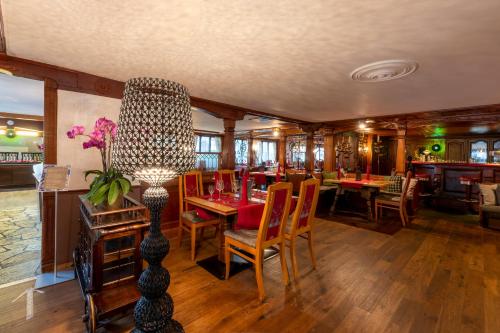 un comedor con mesa y sillas y un restaurante en Golf & Alpin Wellness Resort Hotel Ludwig Royal, en Oberstaufen