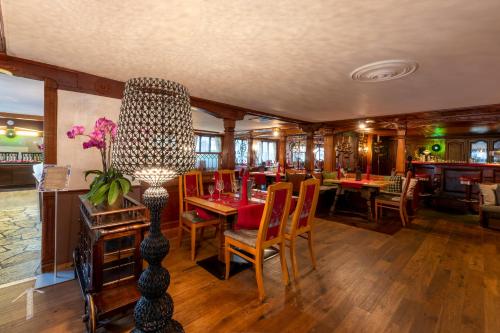 a dining room with a table and chairs and a restaurant at Golf & Alpin Wellness Resort Hotel Ludwig Royal in Oberstaufen